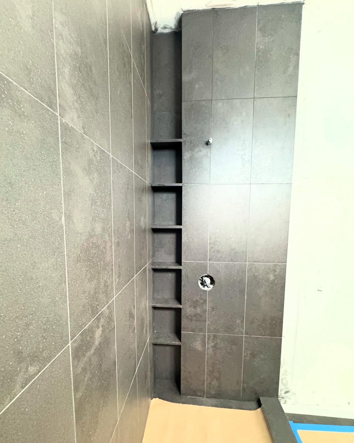 Grey large-format slab shower with recessed niche